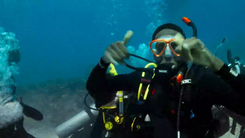 A scuba diver waving underwater
