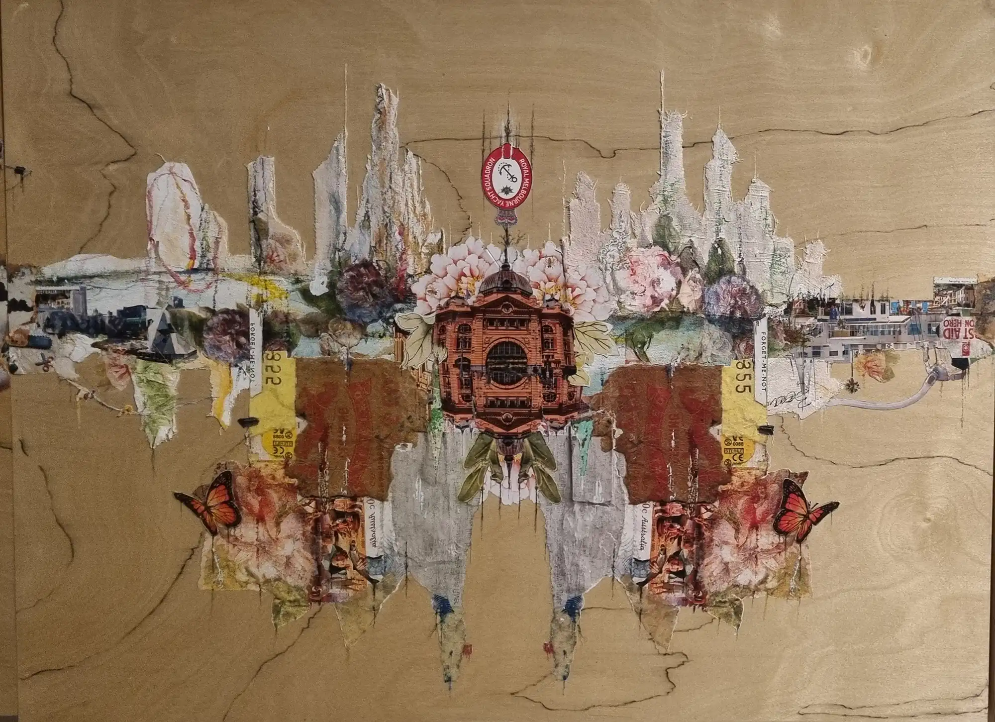 A mirrored mixed media collage on wood, centred on Melbourne’s Flinders Street Station with flowers and butterflies
